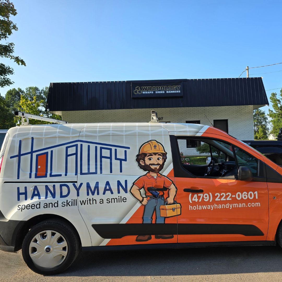 Holaway Handyman - Square A white van with HOLAWAY HANDYMAN branding, featuring a cartoon handyman holding tools, is parked in front of a building with a WRAPOLOGY sign. The van lists a phone number and website for handyman services.